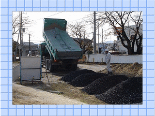 ダンプカーが砂利を敷く様子